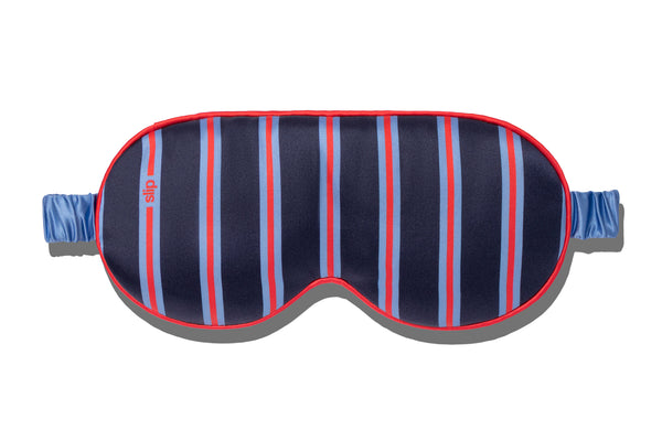 Striped slip silk sleep mask with blue and red pattern on a white background