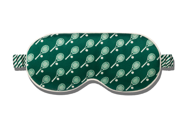 Green silk sleep mask with tennis racket pattern on a white background
