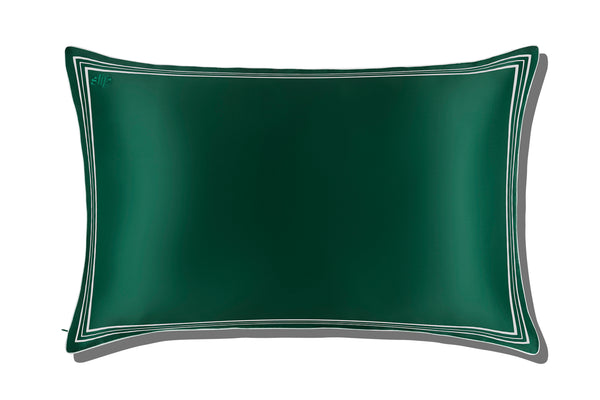 Green silk pillowcase with white decorative trim on a white background