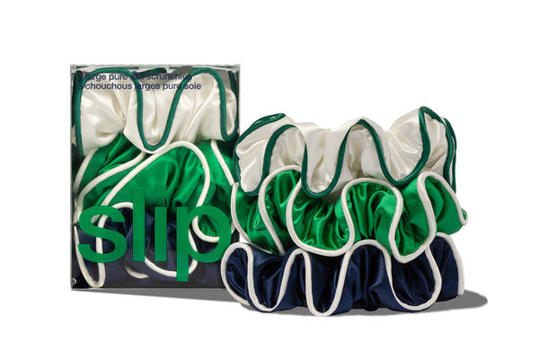 Set of green, navy and white silk hair scrunchies with slip branded packaging on a white background