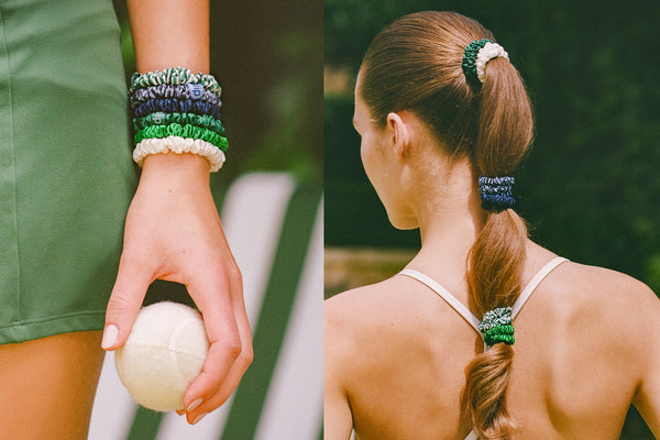 Person holding a ball with green, blue and white silk skinny scrunchies on wrist and hair, outdoors.